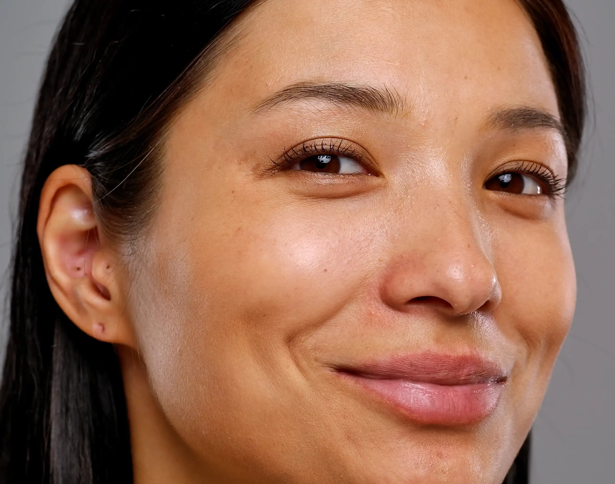 Young woman with brown hair and eyes and a warm smile