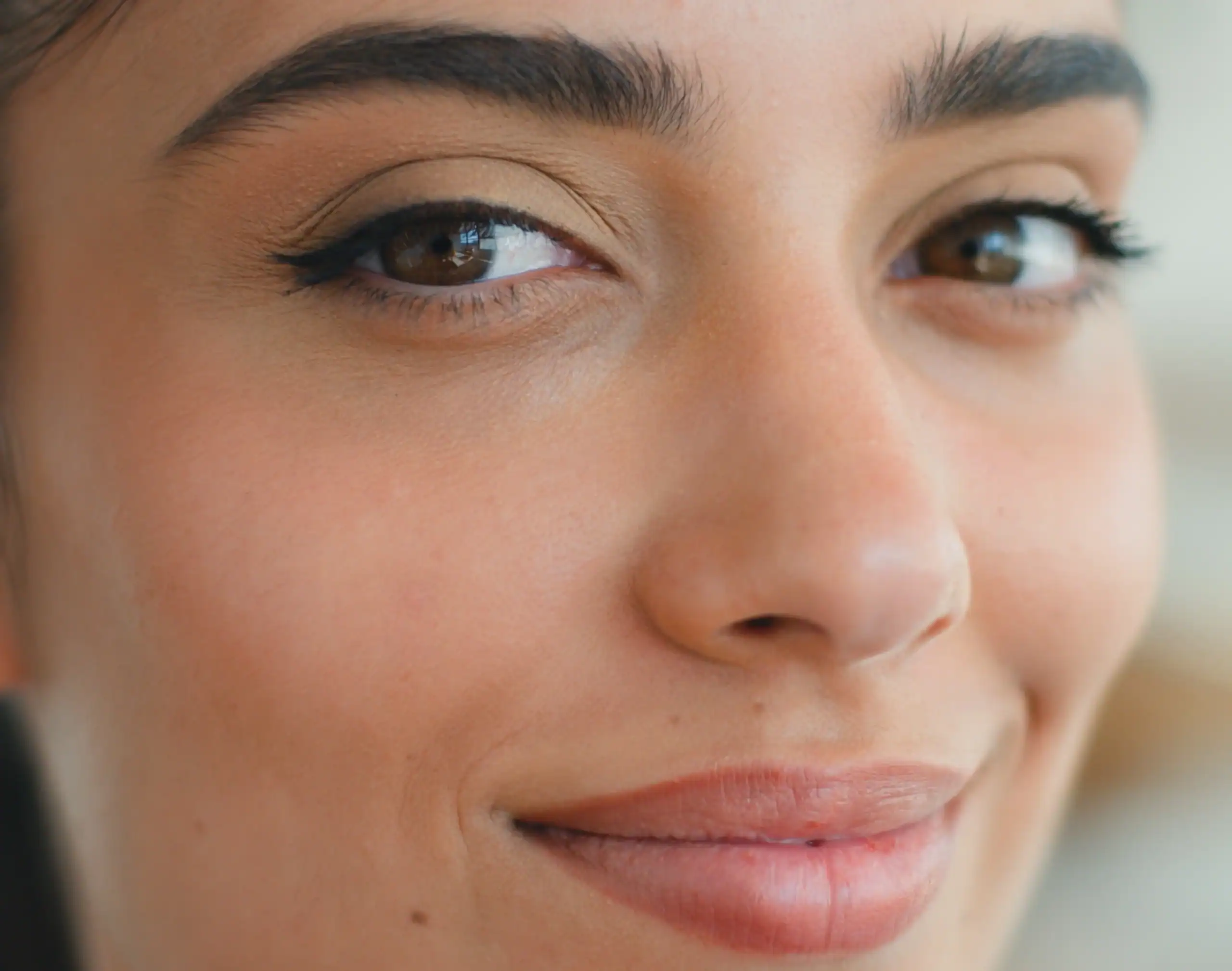 Woman with brown eyes and full lips, referencing cosmetic dermatology