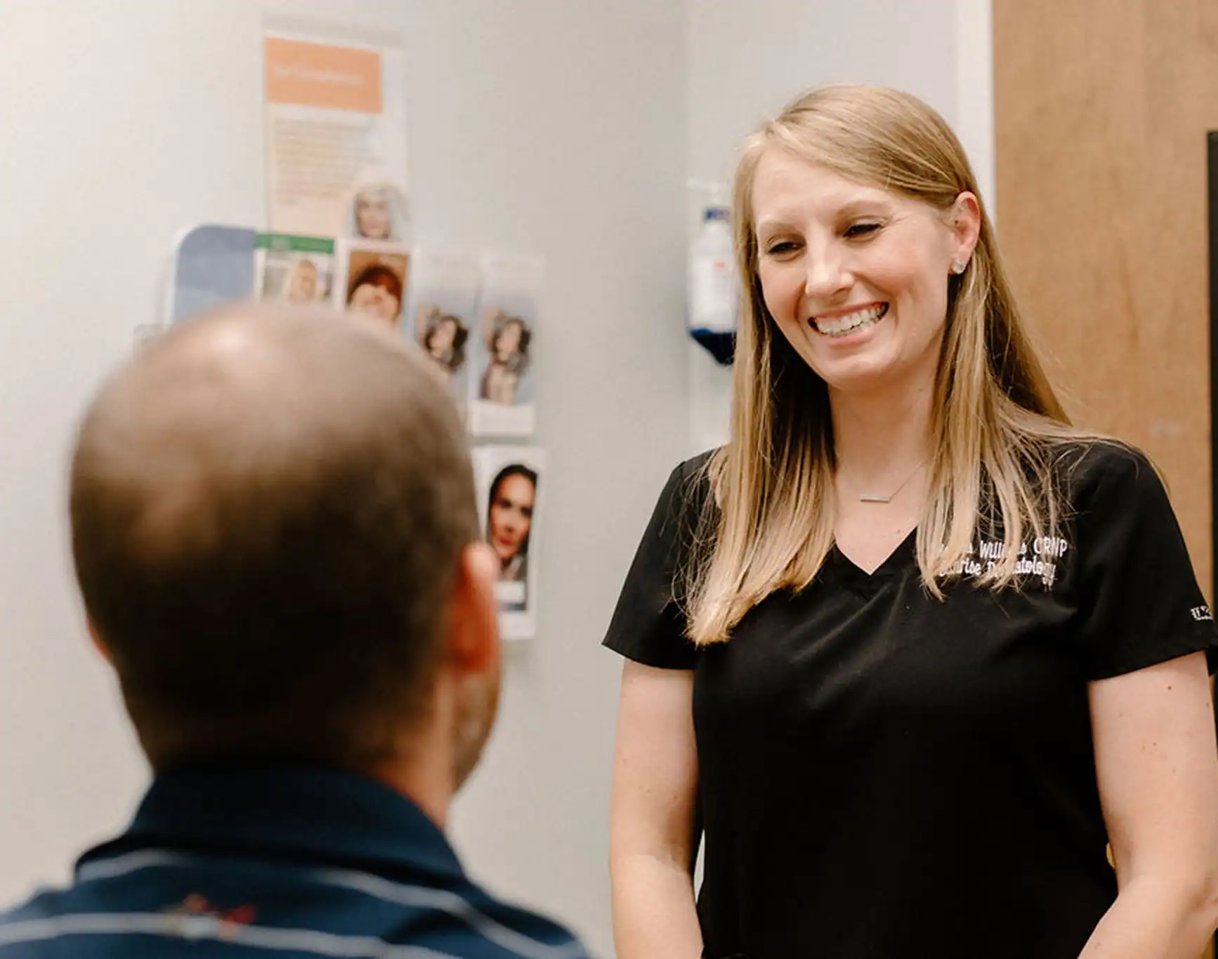 Nurse Melissa Williams, CRNP, smiles while working with a patient at Sunrise