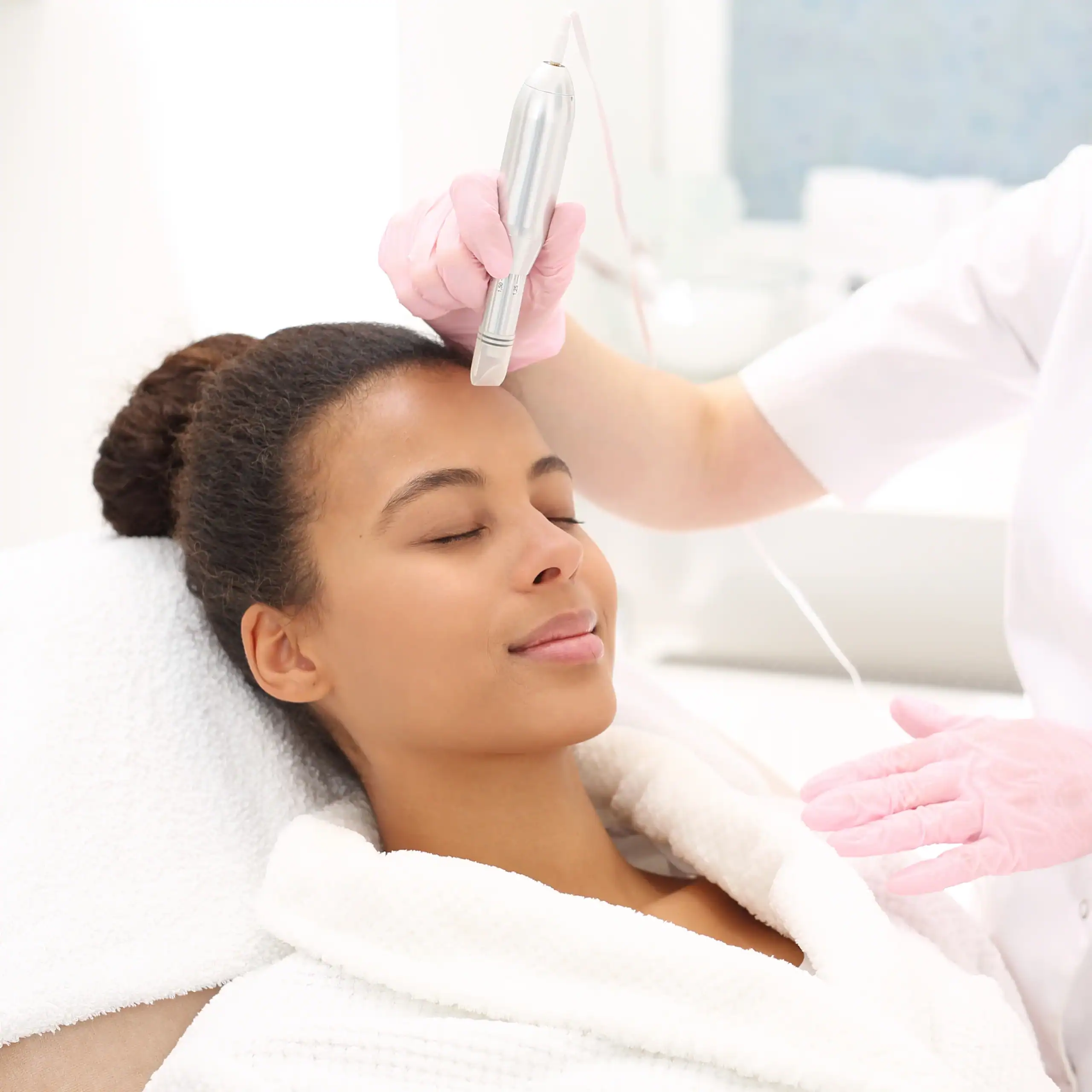 Young Black woman with beautiful skin gets a microneedling treatment